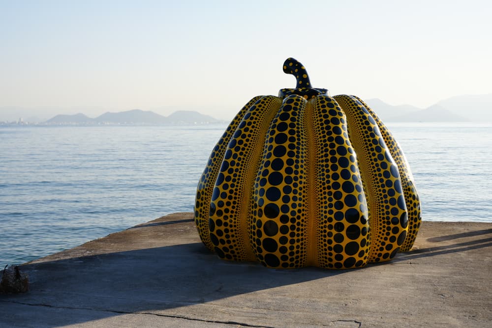 Yayoi Kusama's yellow pumpkin on the pier at Naoshima, sea behind it